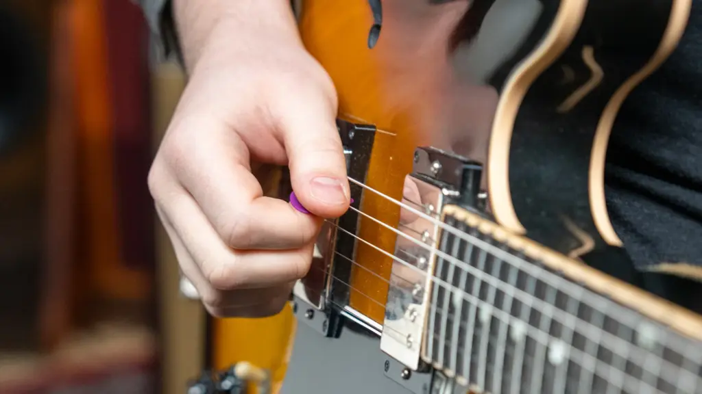 A person holding a guitar pick